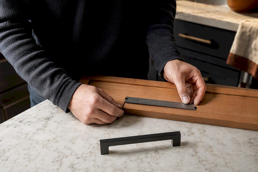 Hands measuring cabinet pull spacing