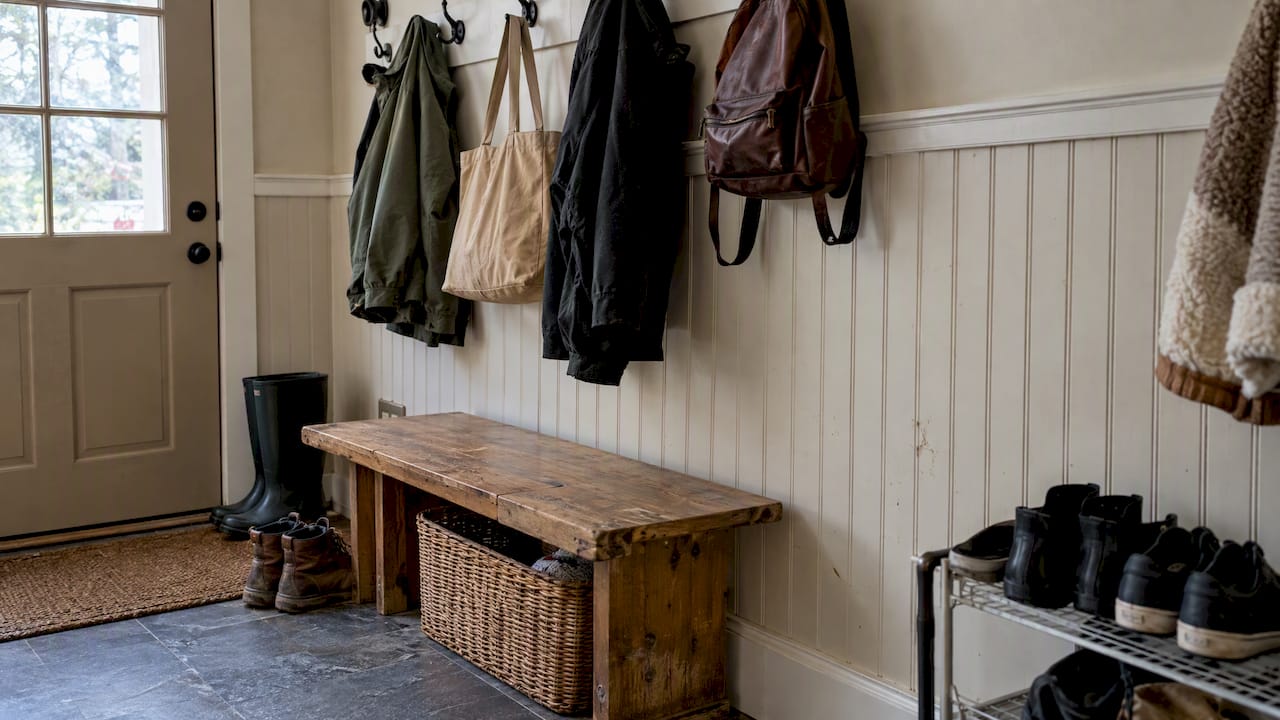 Beadboard mudroom wall with hooks and boots