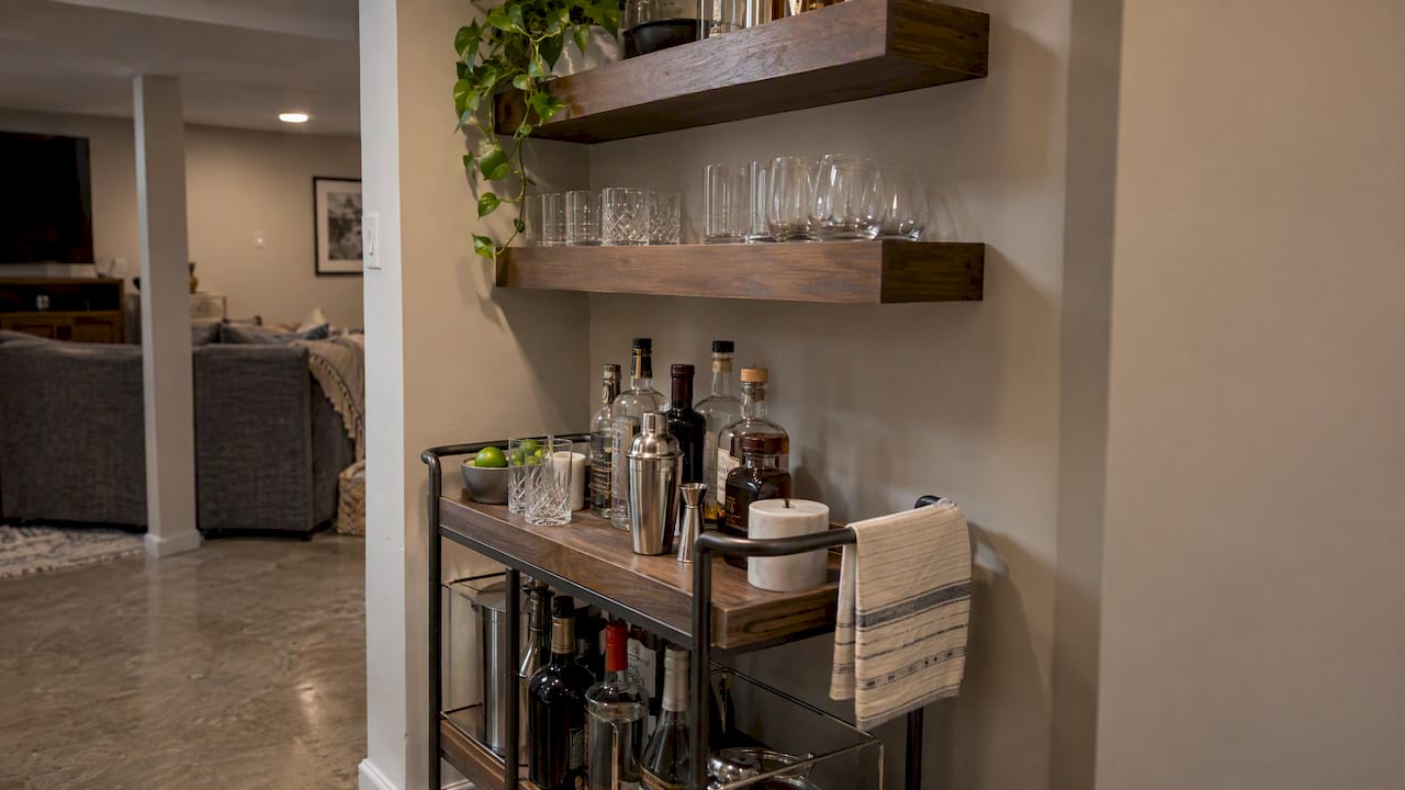 Compact bar cart beneath floating basement shelves